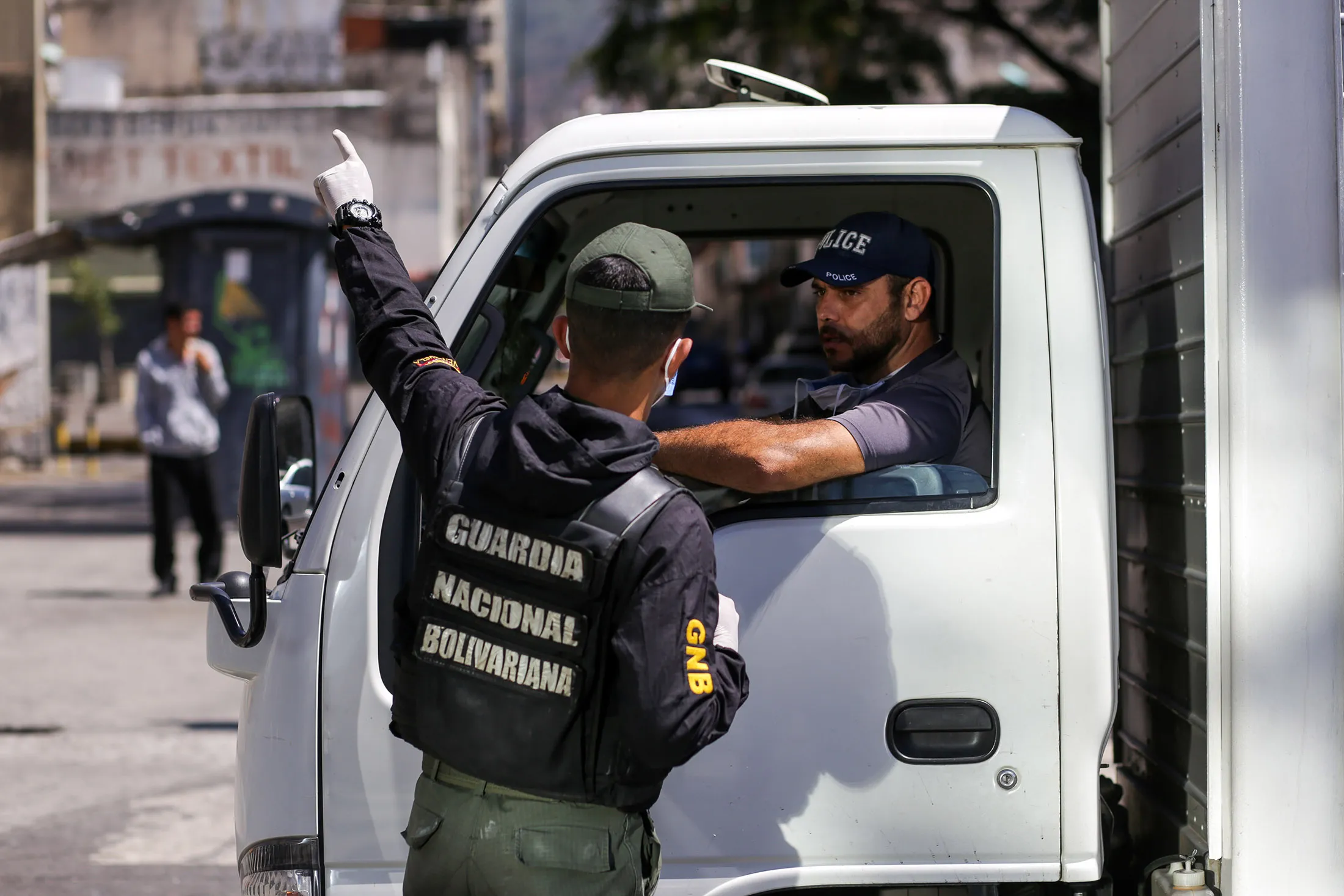 A member of the Bolivarian National Guard gives instructions to a driver in Caracas on March 17.