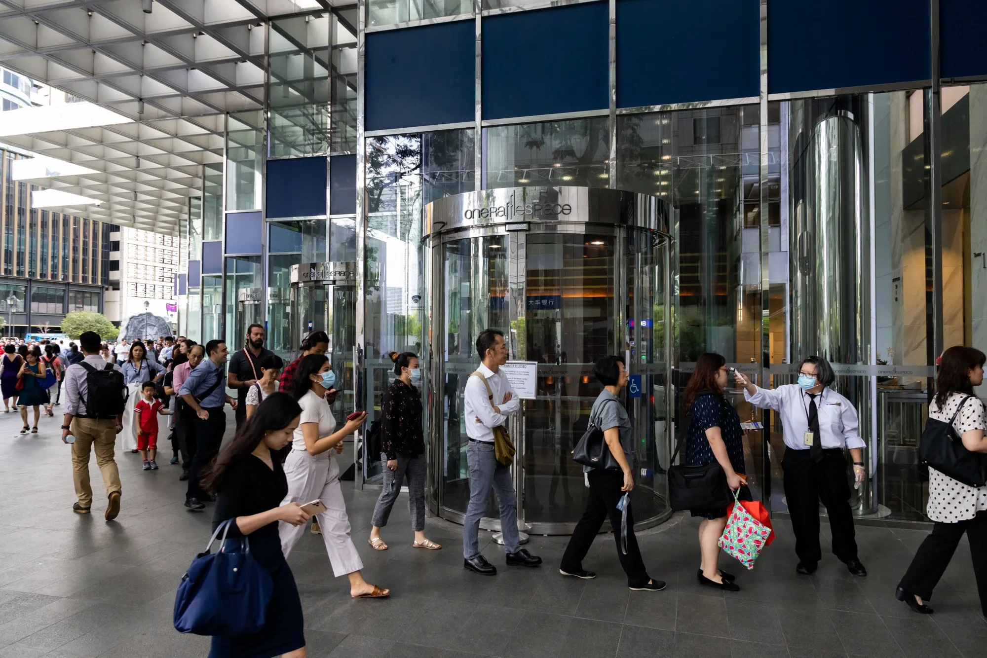 People line up for a temperature check outside an office building in Singapore, Feb. 2020.