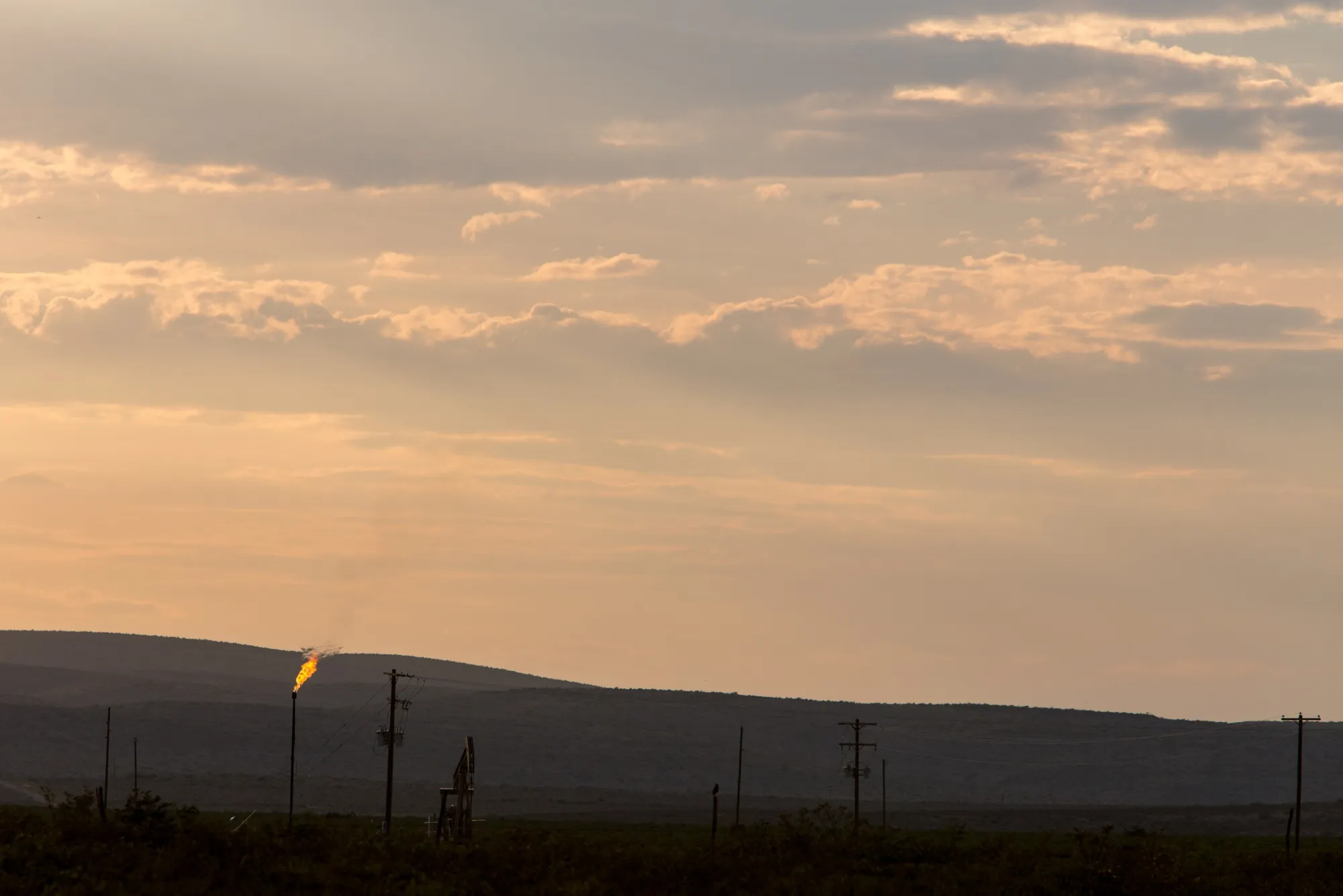Methane gas is flared just off U.S. Route 285 near Carlsbad, New Mexico, U.S., on Tuesday, Aug. 6. 2019. New Mexico's Governor Michelle Lujan Grisham is balancing her concern over the catastrophic effects of climate change with the state's extraordinary dependence on oil and gas.