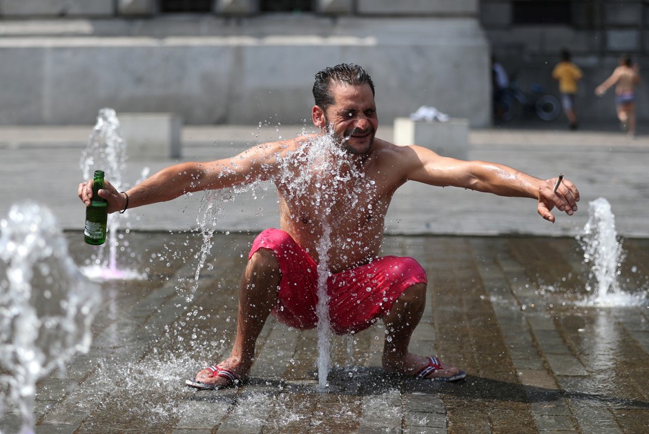A man cools off in a fountain in Brussels, where temperatures today approached 100 degrees Fahrenheit.