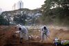 Workers wearing protective equipment bury the casket of a Covid-19 victim at the Vila Formosa cemetery in Sao Paulo, Brazil.