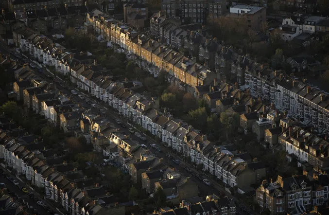 Early morning sunlight highlights a row of terraced houses as they stand on a residential street in London, U.K., on Thursday, Dec. 19, 2013.