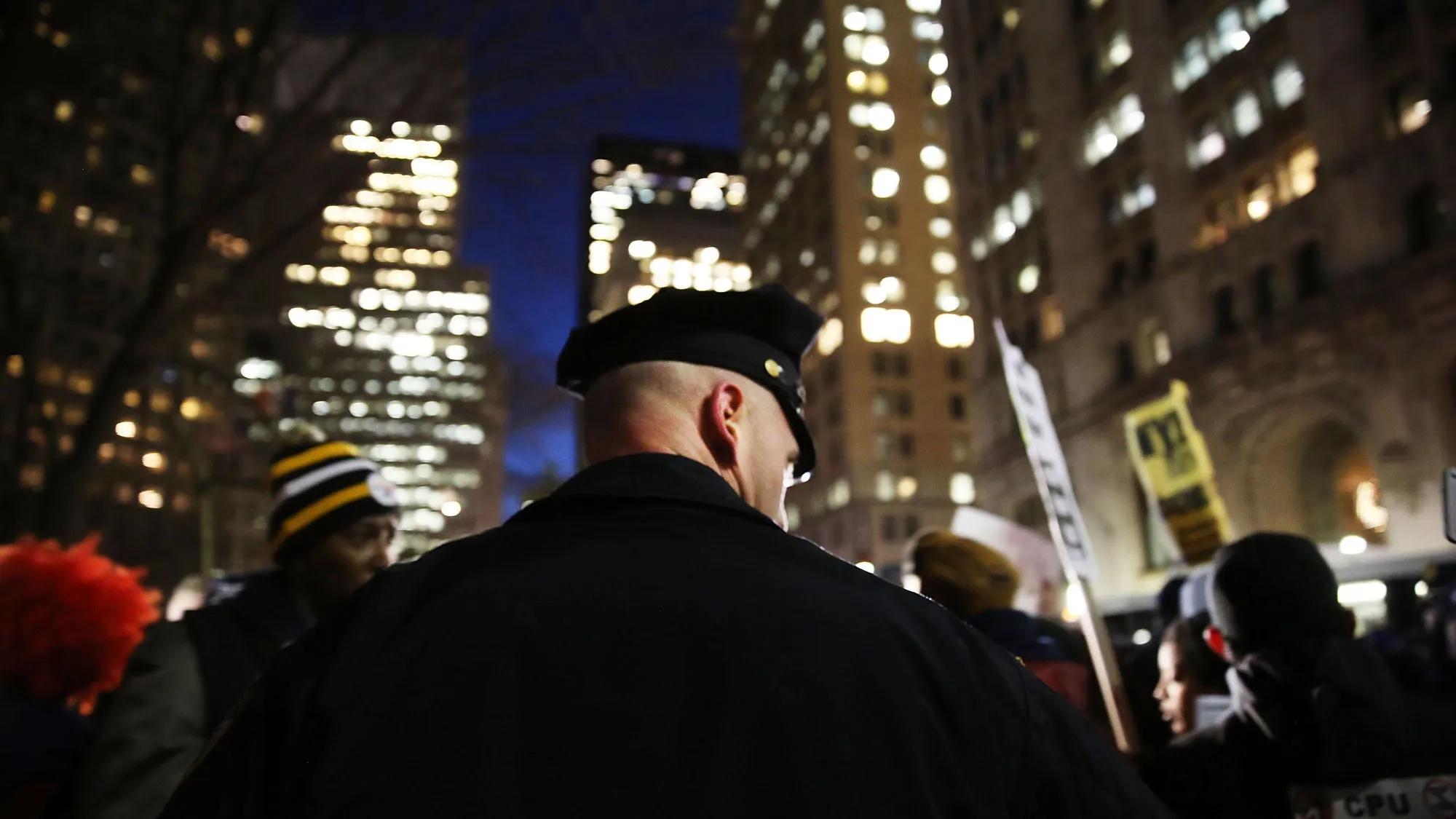 A police officer stands guard as people demonstrate outside of City Hall against police violence at a rally that was supposed to be in support of the New York Police Department (NYPD) on December 19, 2014 in New York City.
