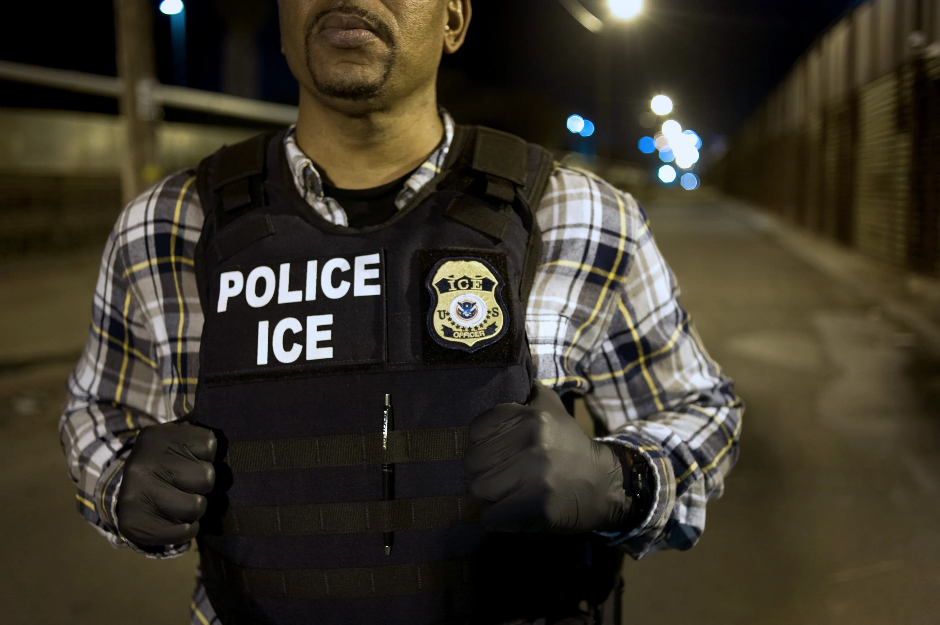 A U.S. Immigration and Customs Enforcement (ICE) agent waits as a group of undocumented men, not pictured, are deported to Mexico at the U.S.-Mexico border in San Diego, California on&nbsp;Feb. 26, 2015.&nbsp;