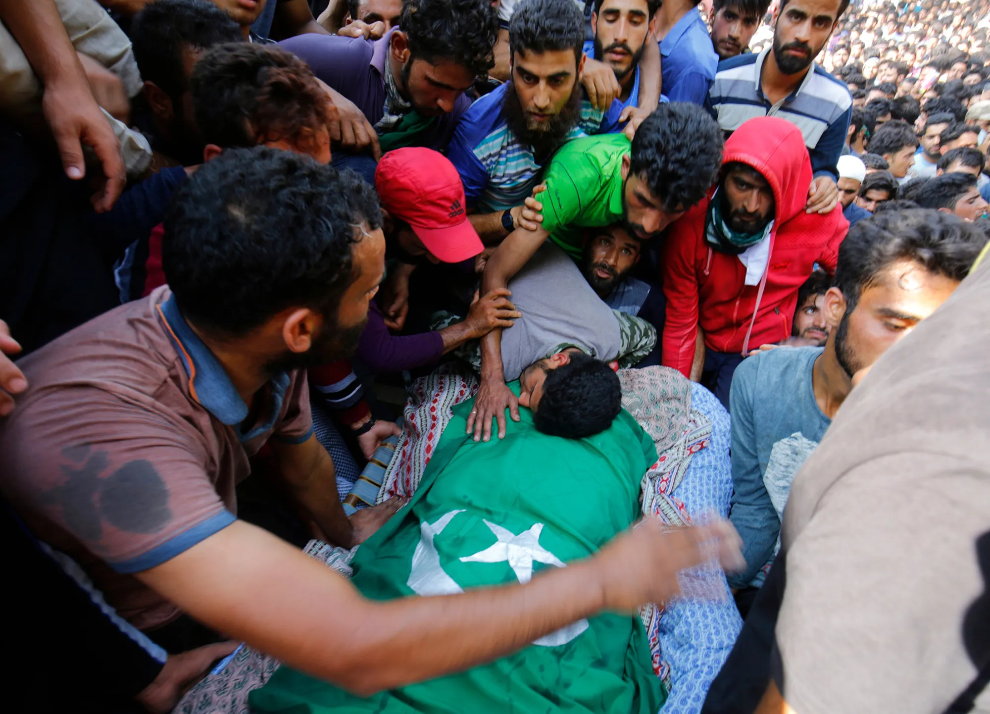 People gather around the body of Shabir Ahmad Mir, a suspected militant, during his funeral procession anear Srinagar, on July 30.
