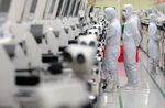 Employees work on the production line of Hana Micron Inc.'s plant in Asan, South Korea, on Wednesday, Nov. 11, 2009.