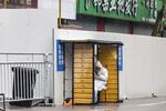 A worker sits under a temporary shelter at a neighborhood placed under lockdown due to Covid-19 in Shanghai on March 25.