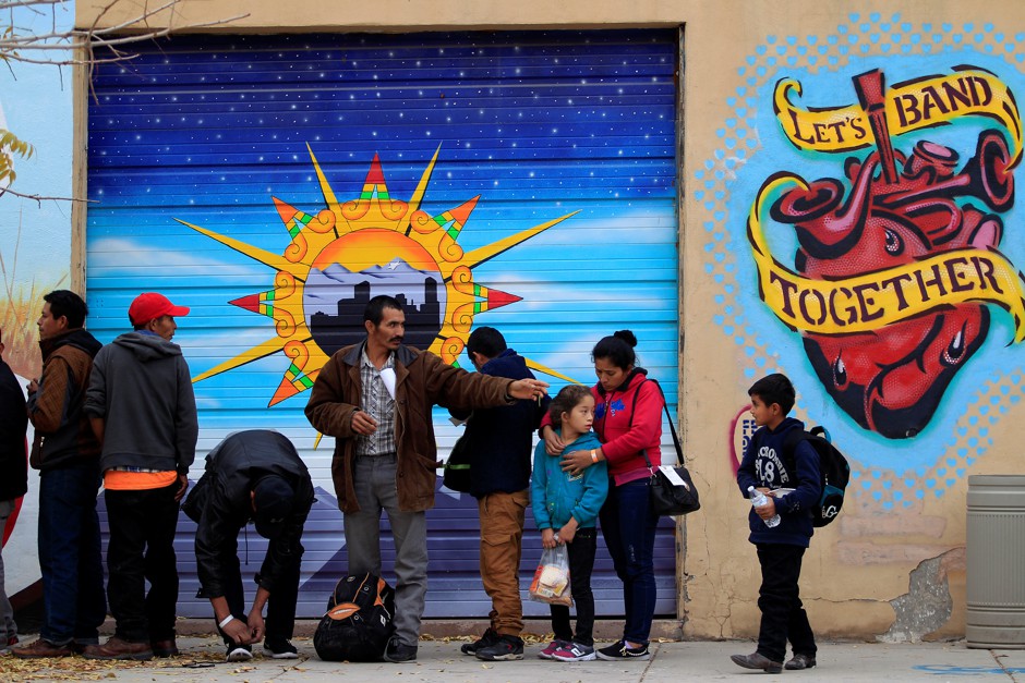 A group of Central American migrants queue for food as they wait for transportation to emergency shelters in El Paso, Texas.
