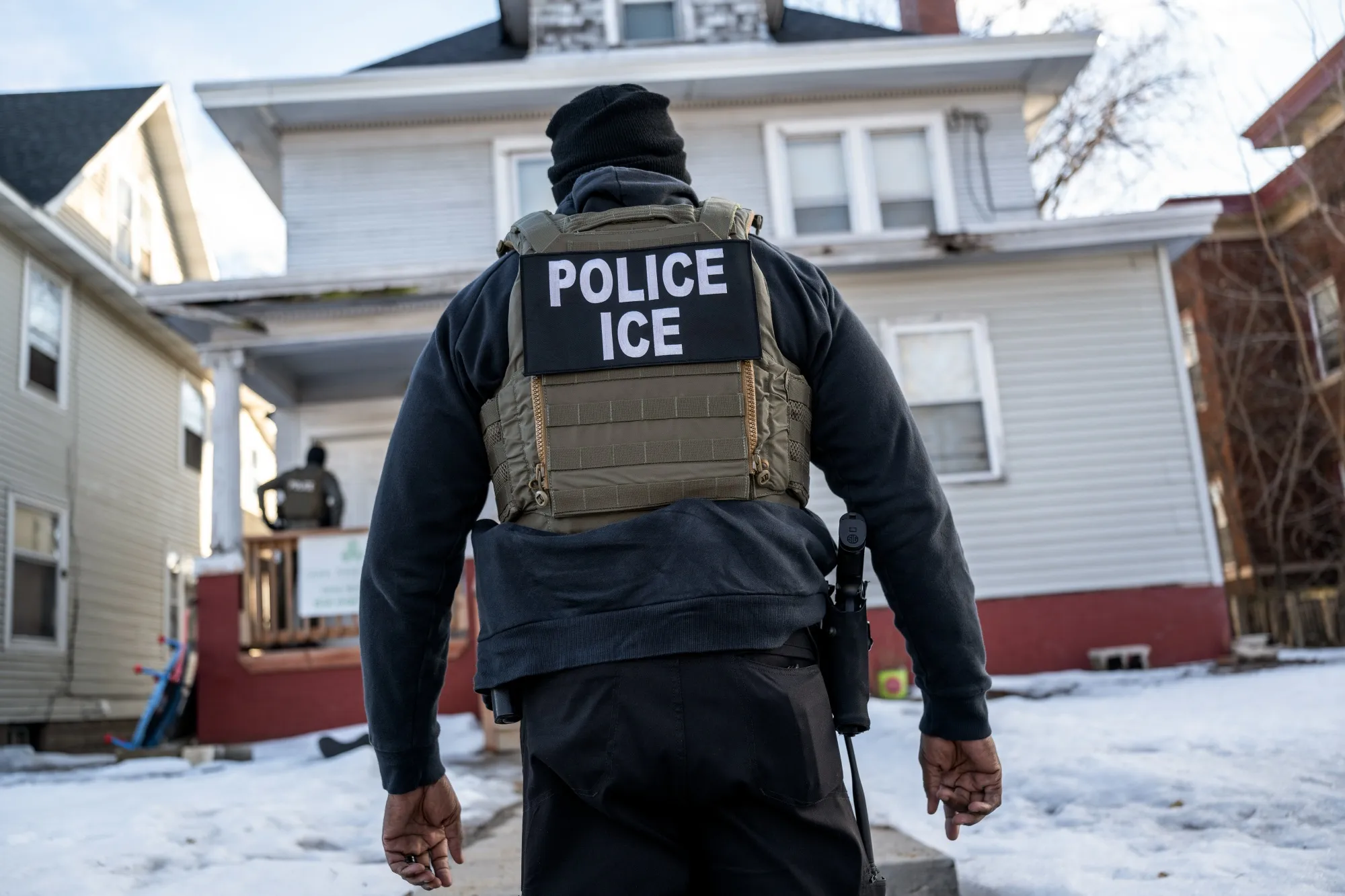 A federal law enforcement agent outside a home during a raid in south Minneapolis, Minnesota.