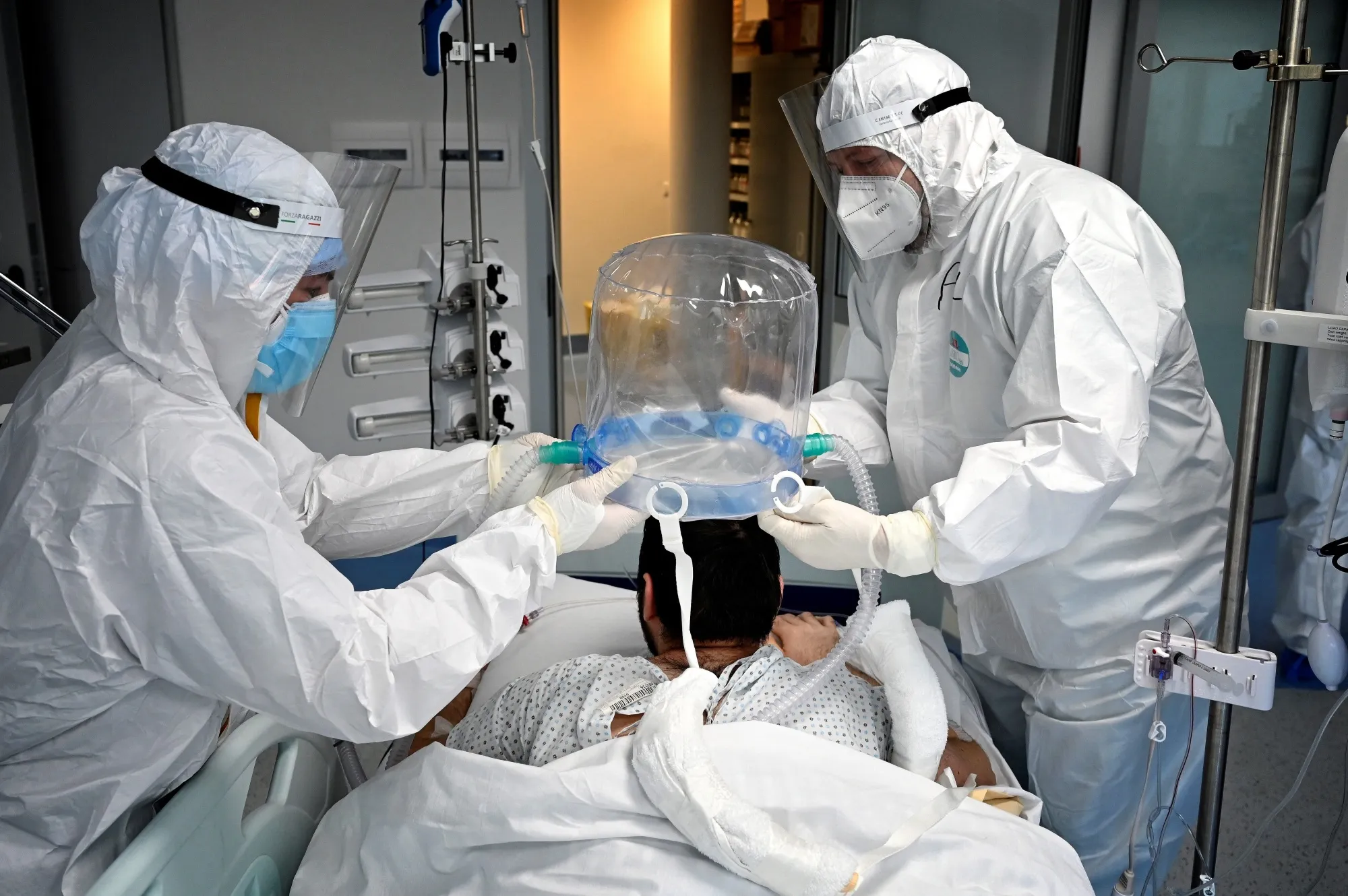 Medical staff members help a patient wear a new non-invasive technology that can reduce the need of intubation at Covid-19 intensive care unit&nbsp;in Rome, on Dec. 30.