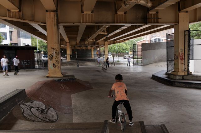 A child rides a bicycle on a skate ramp skateboarders at Golconda Skate Park under the Brooklyn Queens Expressway.
