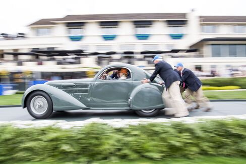 Volunteers push a vehicle off the show ramp during the 2016 Pebble Beach Concours d'Elegance in Pebble Beach, Calif., on Aug. 21, 2016.