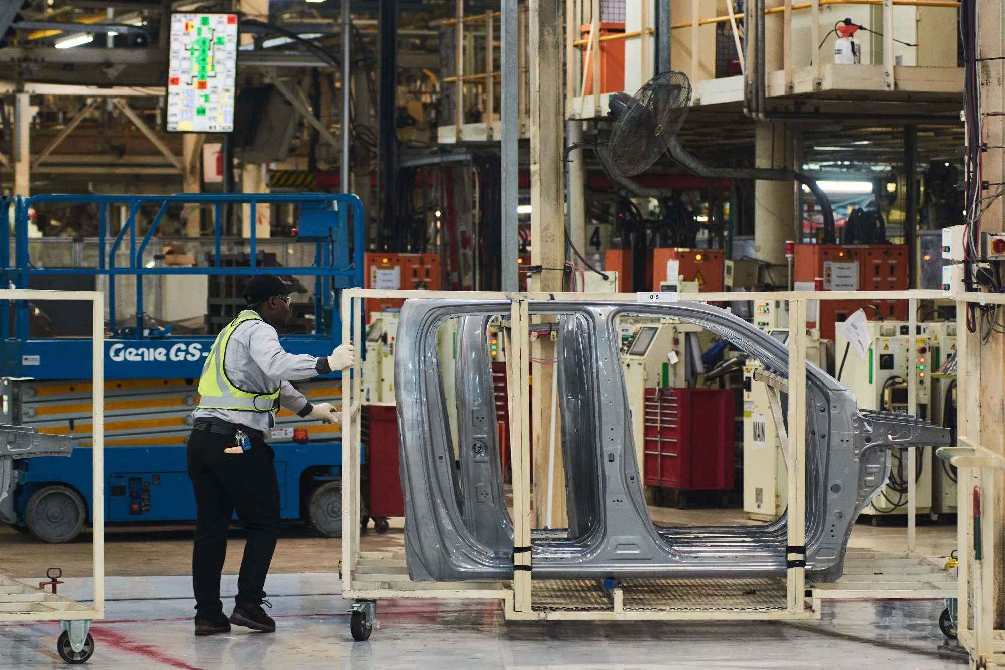 A worker moves a cradle carrying steel automobile panels at a&nbsp;manufacturing plant in Durban, South Africa.