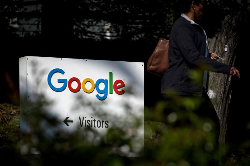 A pedestrian walks past signage at Google Inc. headquarters in Mountain View, California.