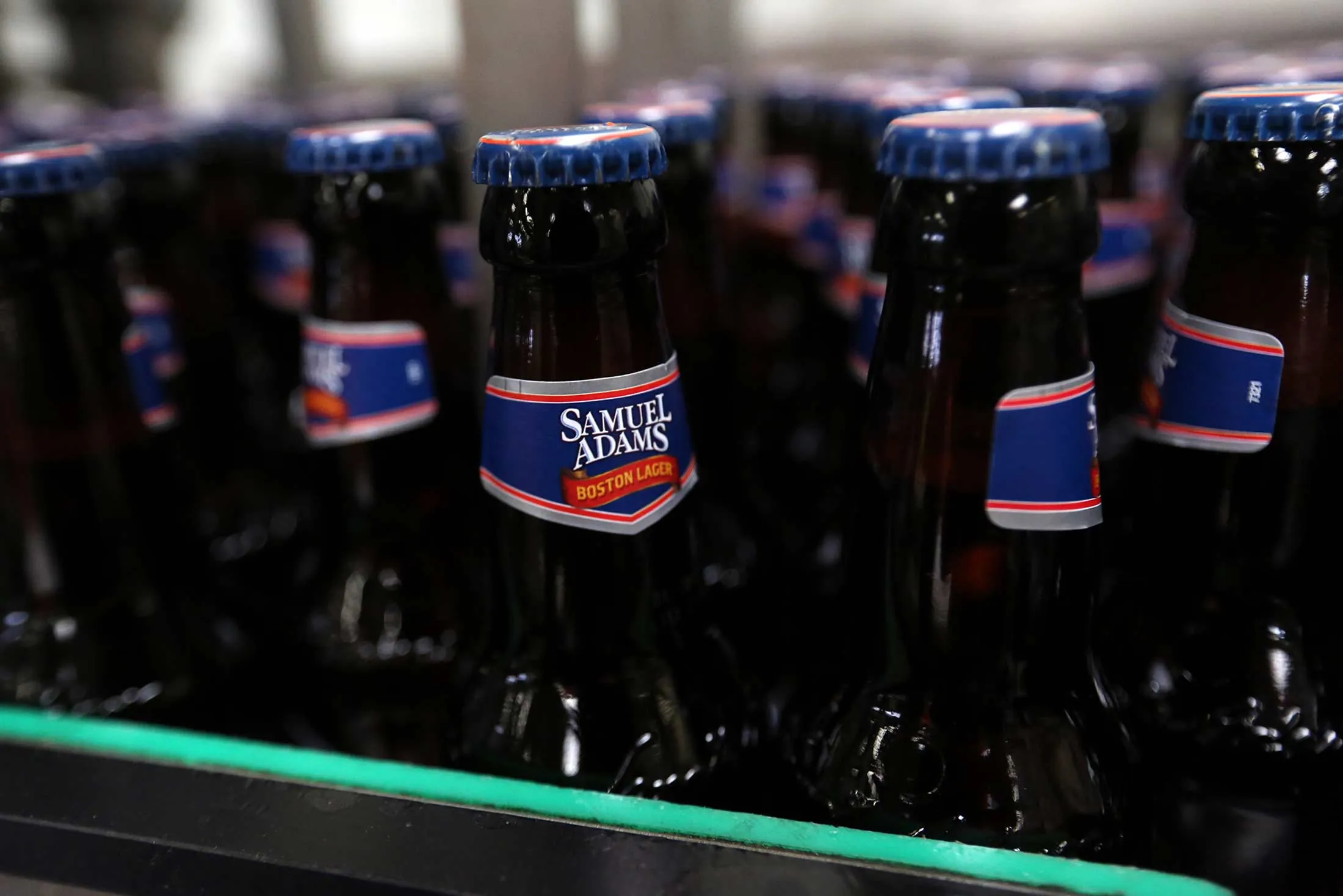 Bottles of Samuel Adams Boston Lager travel along the production line in a bottling house at the Shepherd Neame Plc brewery in Faversham, U.K.
