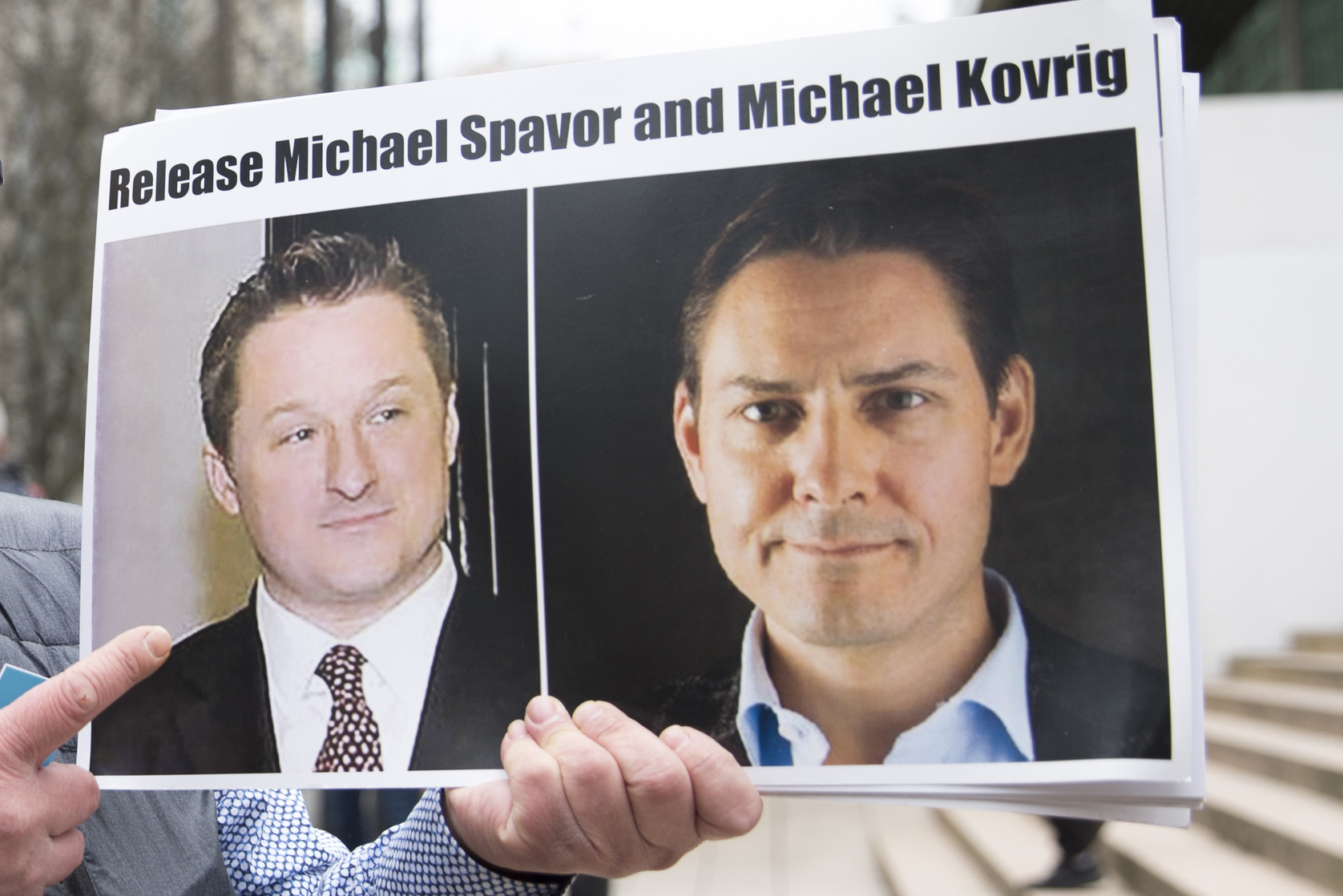 Photos of Michael Spavor and Michael Kovrig are shown outside a Vancouver courthouse in 2019.