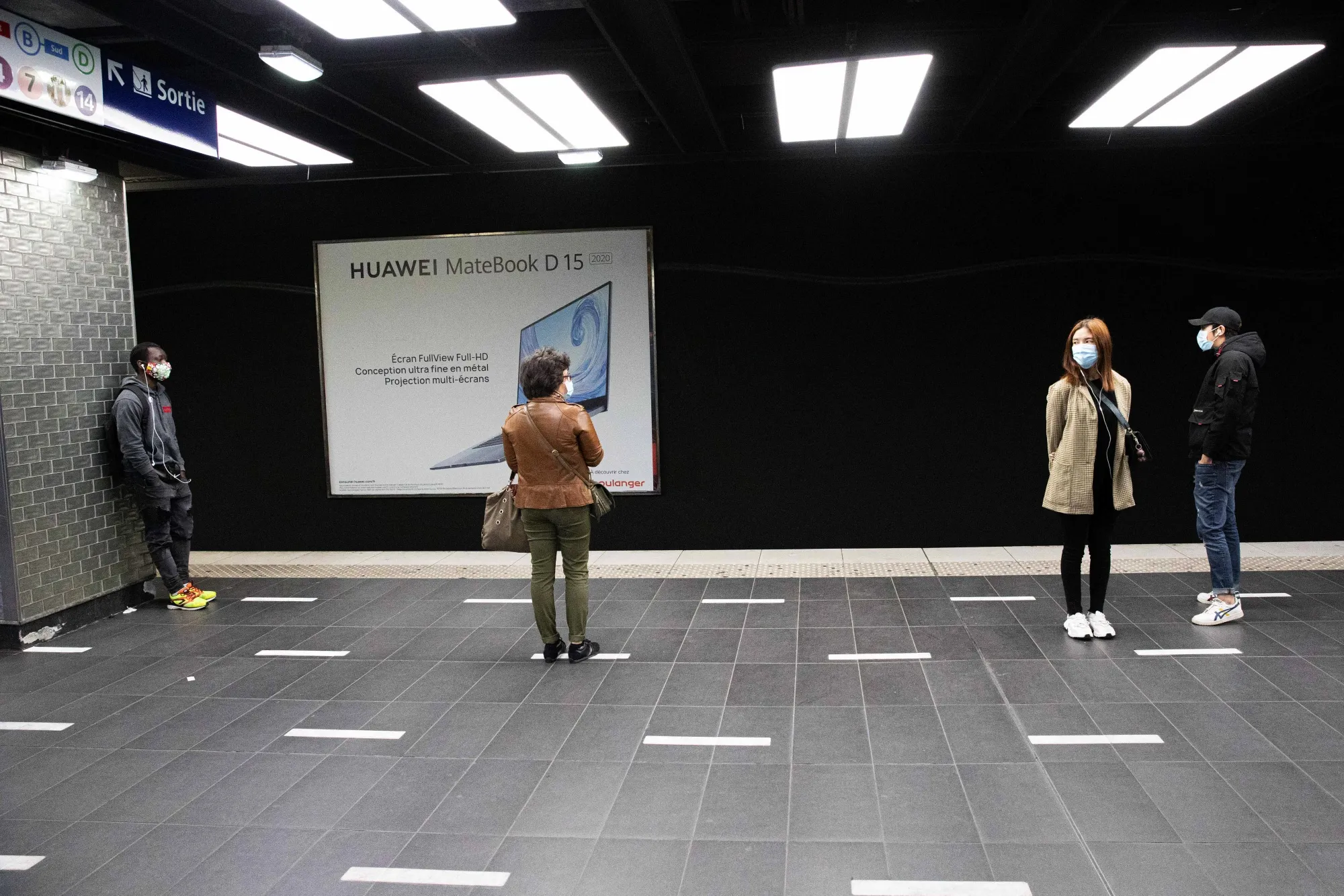 Travelers stand near social distancing floor markers on a train platform at Chatelet-Les-Halles metro station station in Paris on May 12.