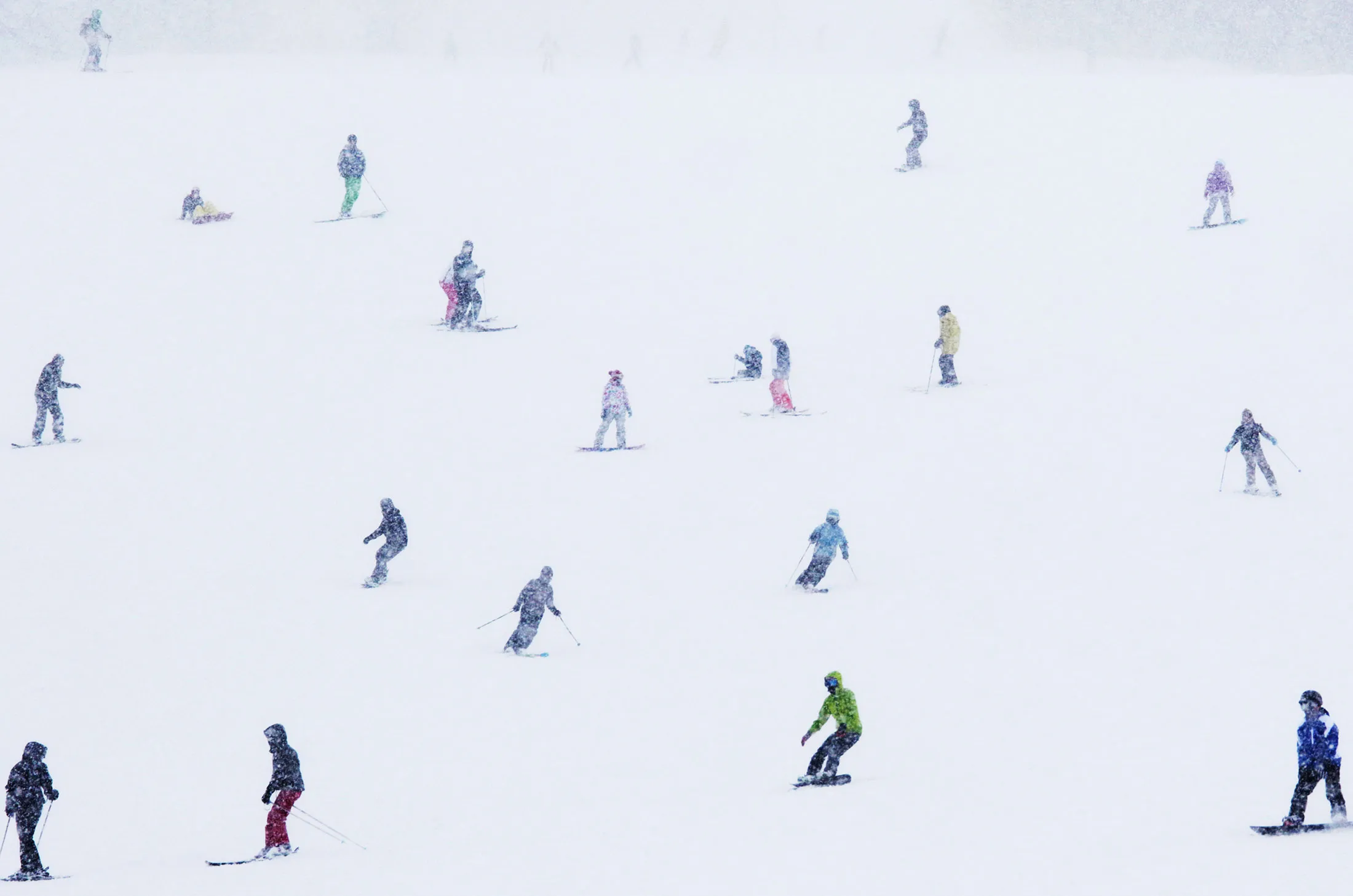 Skiers and snowboarders ride down a slope&nbsp; in Hokkaido, Japan.