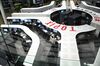 Employees work at the trading floor of the Tokyo Stock Exchange in Tokyo, Japan, on Tuesday, Nov. 22, 2011. Tokyo Stock Exchange Group Inc. agreed to acquire Osaka Securities Exchange Co. for 129.6 billion yen ($1.68 billion) in a transaction to be completed by January 2013.