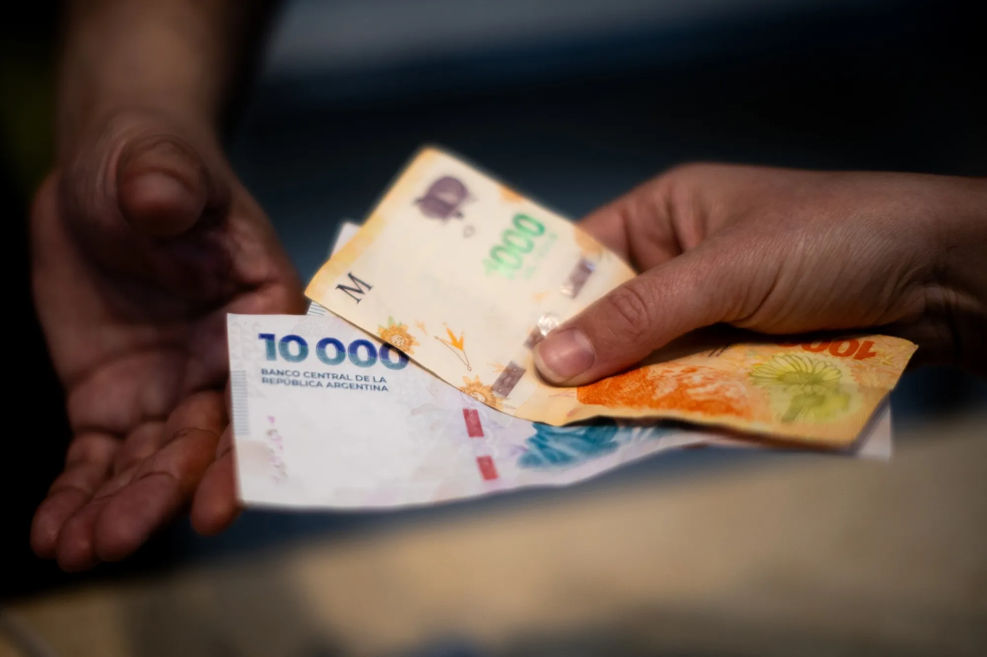 A customer pays with Argentine peso banknotes in Buenos Aires.