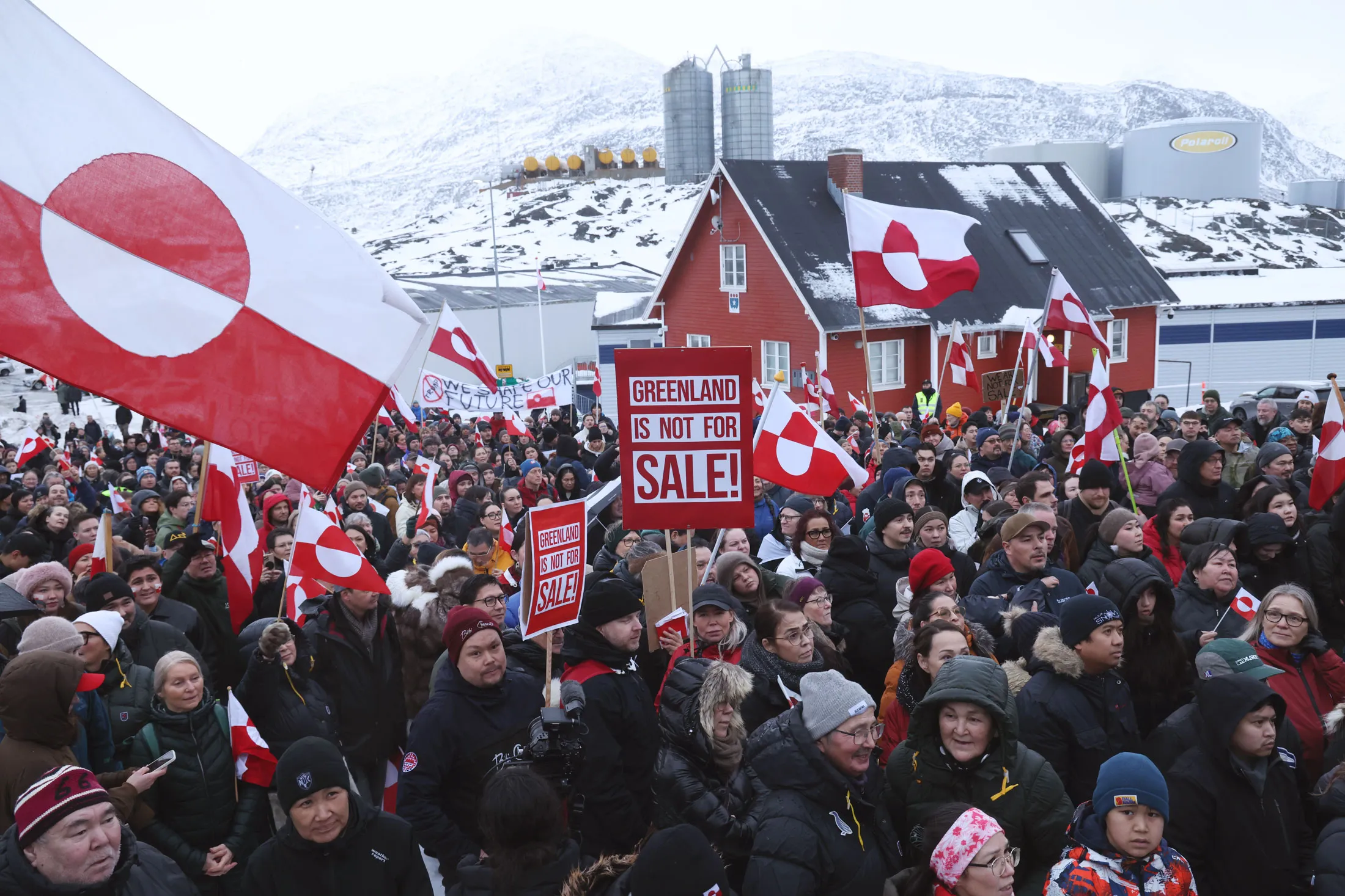 Protesters hold Greenlandic flags and placards outside the US consulate in Nuuk, Greenland.