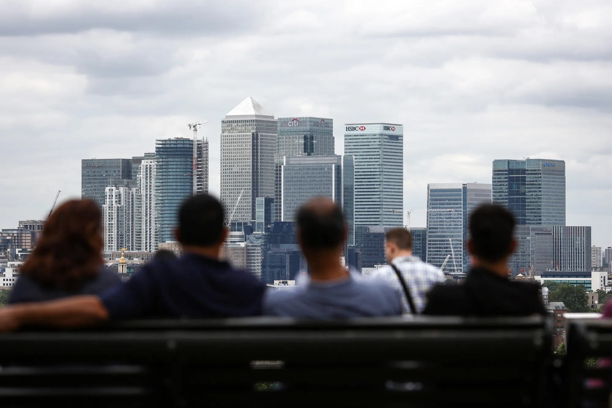 Pedestrians look at the Canary Wharf district in London.