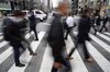 Pedestrians cross a road in Tokyo's business district, Japan, on Friday, March 29, 2019. The Bank of Japan (BOJ) will release its quarterly Tankan business sentiment survey on April 1.