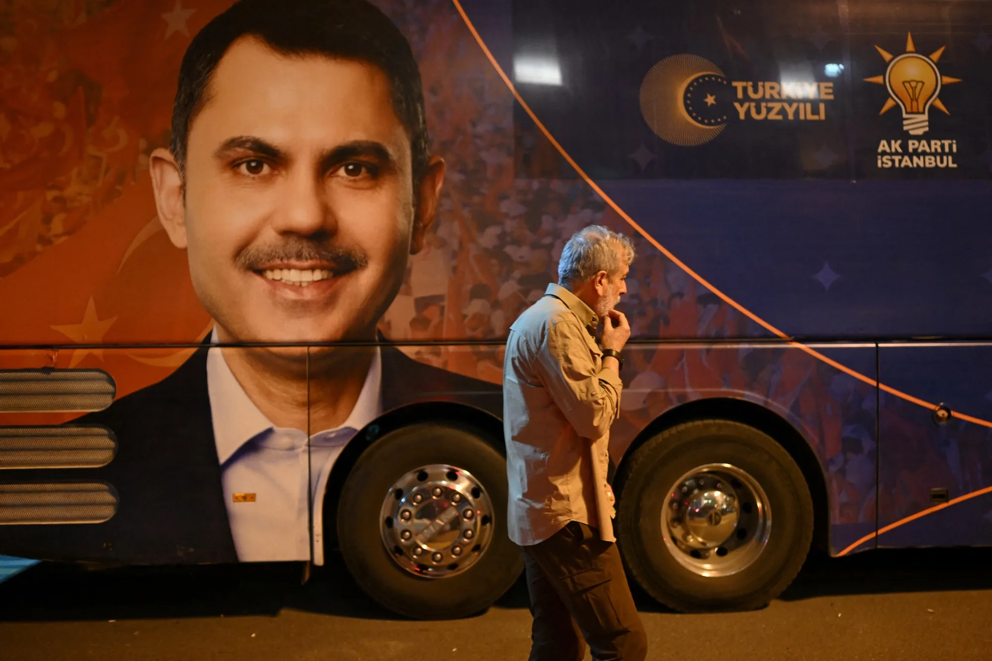 A man walks past a campaign bus of AK Party’s Istanbul mayor candidate&nbsp;Murat Kurum, in Istanbul on March 31.