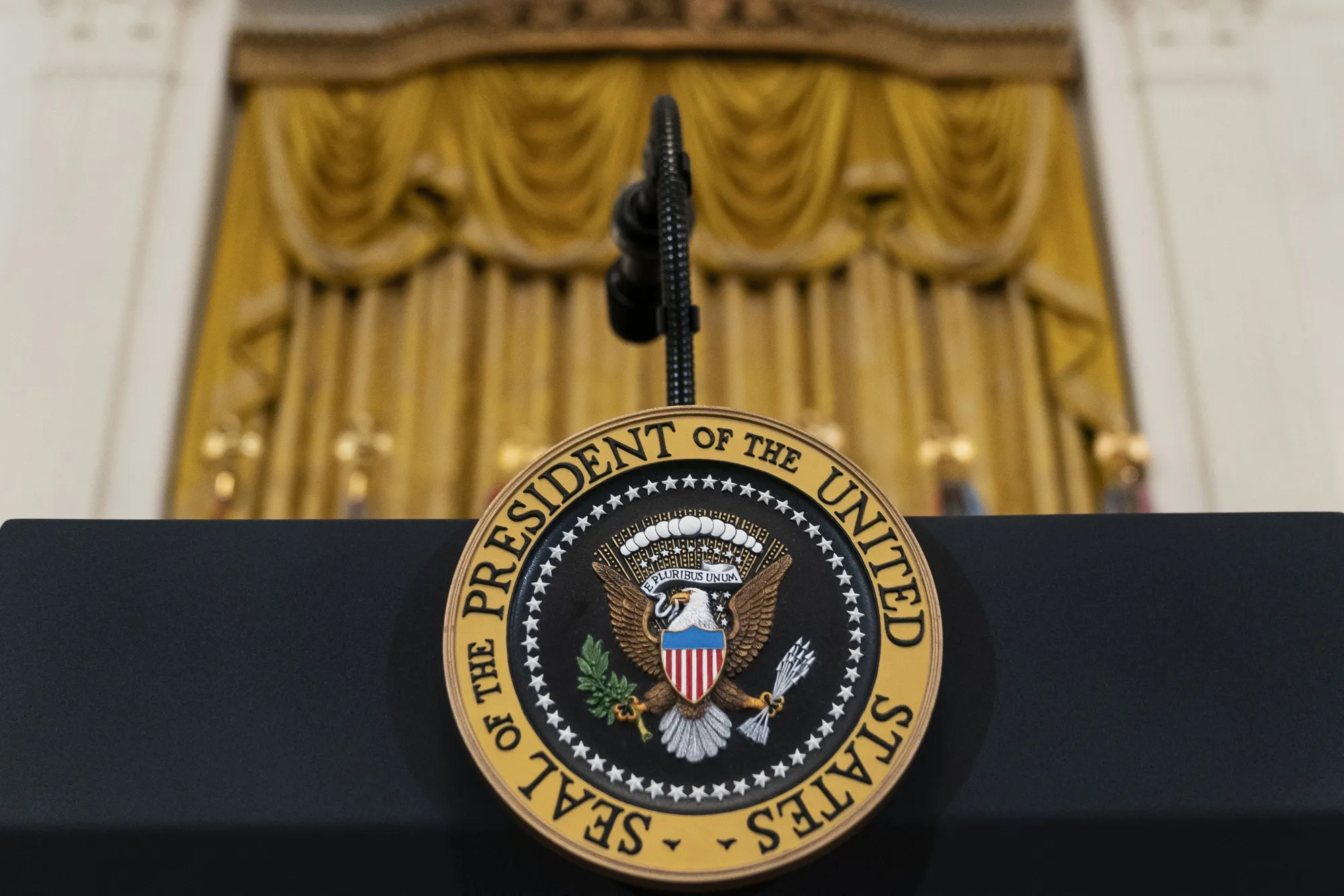 The presidential seal is seen on a podium at the White House.