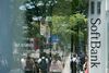 Pedestrians are reflected in the window of a SoftBank Group Corp. store in Tokyo.