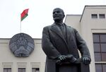 The national flag of Belarus flies on a state building above a statue of former Communist Party founder Vladimir Lenin on Independence square in Minsk, Belarus, on Wednesday, March 16, 2016.