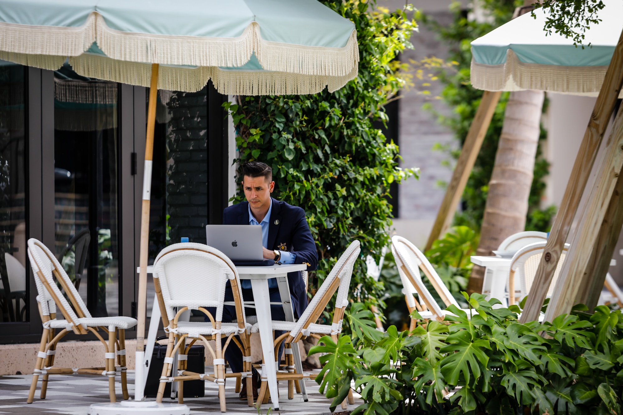 A customer works on a laptop computer in the outdoor dining area of Pura Vida restaurant on Rosemary Avenue in West Palm Beach, Florida, U.S., on Friday, Aug. 27, 2021.&nbsp;