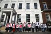 Protesters hold placards outside Chatham House ahead of a speech by Keir Starmer, on Oct. 31, 2023