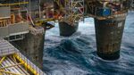 Workers move along an access way above the giant supporting legs of the Oseberg A offshore gas platform operated by Statoil ASA in the Oseberg North Sea oil field 140kms from Bergen, Norway, on Friday, Jan. 17, 2014.