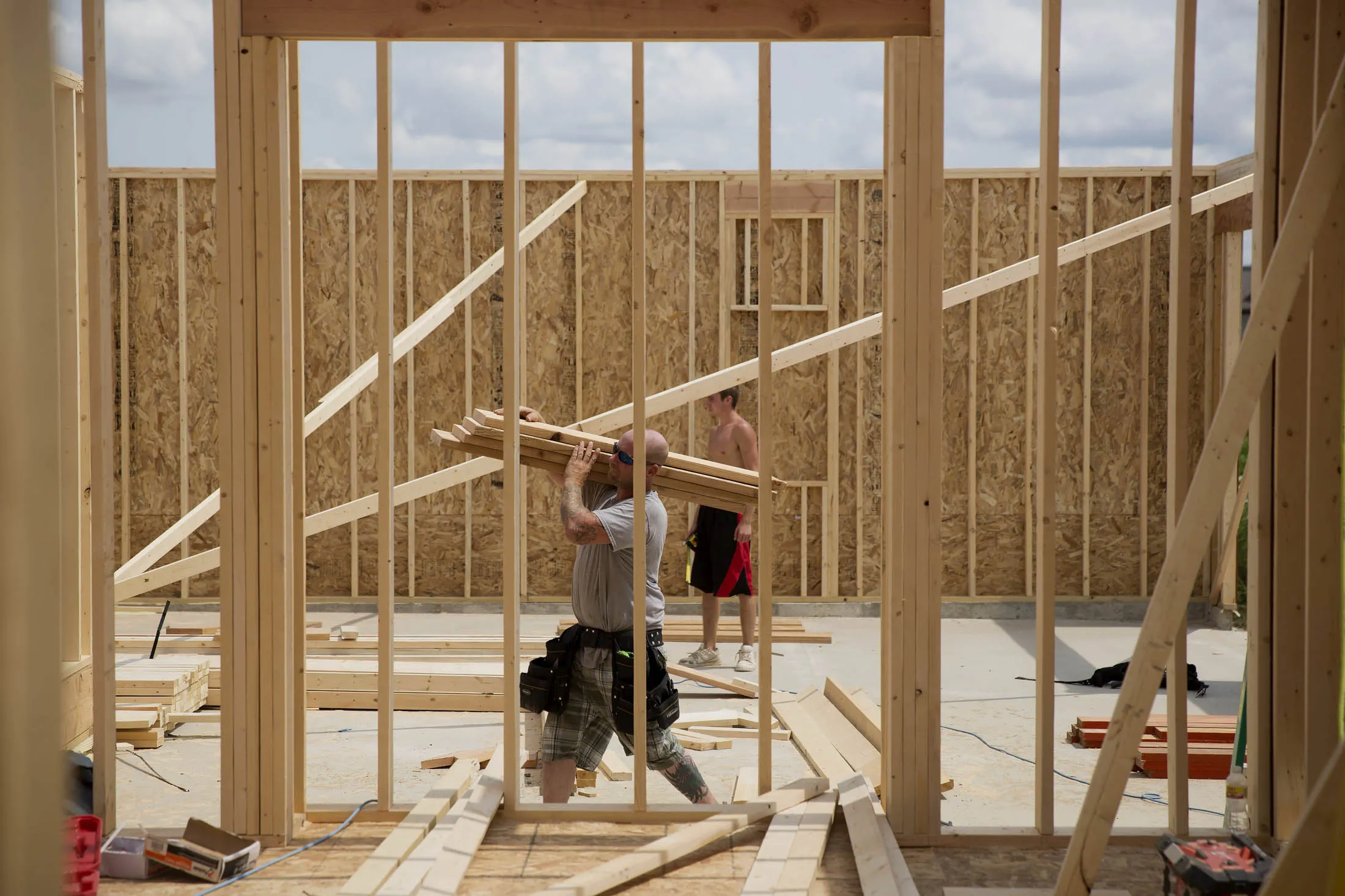 A carpenter carries lumber inside a house under construction in Peoria, Illinois. 