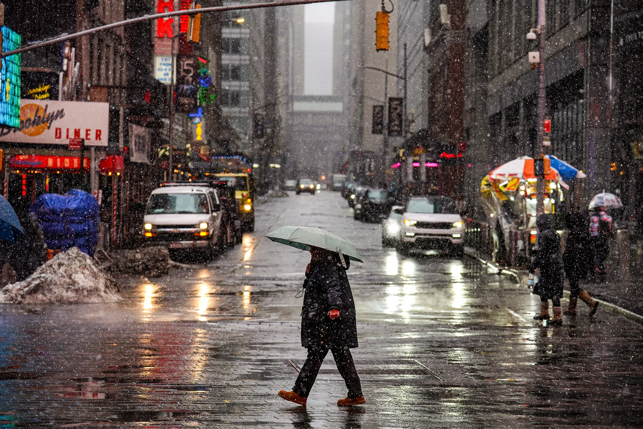 Pedestrians walk along the street as snow falls in New York on Feb. 22.