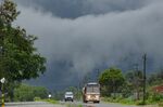 Vehicles make their way against the backdrop of rain clouds on the outskirts of Bangalore.