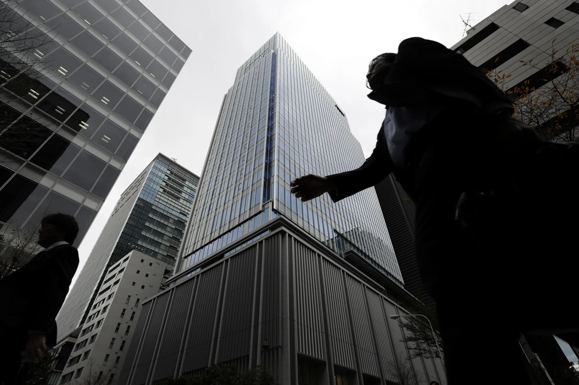 Pedestrians walk past the Takeda Pharmaceutical Co. global headquarters, center, in Tokyo.
