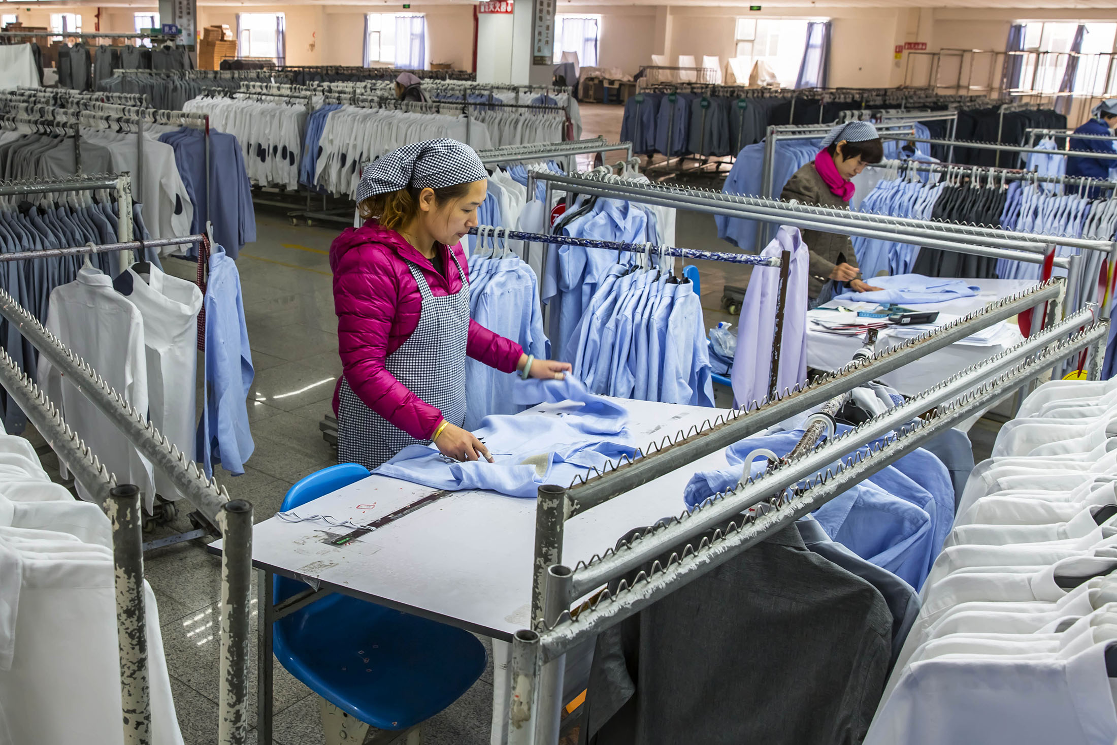 A woman works in a shirt factory in Nantong, in China's Jiangsu province on December 1, 2016. China's manufacturing activity growth accelerated in November, official data showed, reaching its fastest pace in more than two years as cheap credit and improving demand helped revive industry in the world's second-largest economy. / AFP / STR / China OUT (Photo credit should read STR/AFP/Getty Images)
