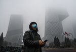 A man wears a protective mask as he stands&nbsp;in the central business district in Beijing, on Feb. 13.