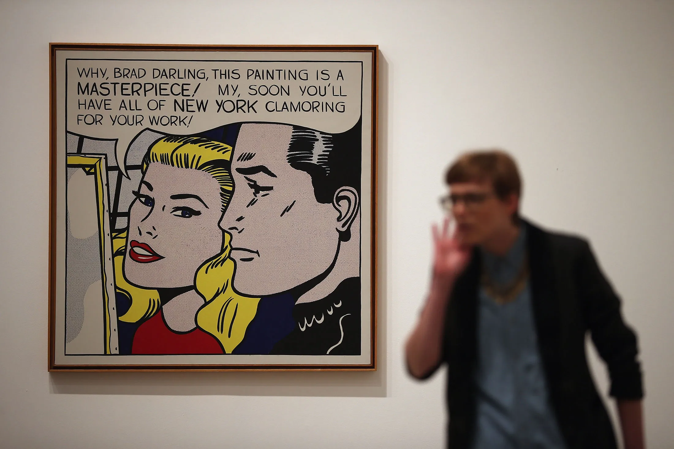 A visitor stands in front of a painting entitled 'Masterpiece,' during a press preview of 'Lichtenstein, a Retrospective' at the Tate Modern on Feb. 18, 2013 in London.

