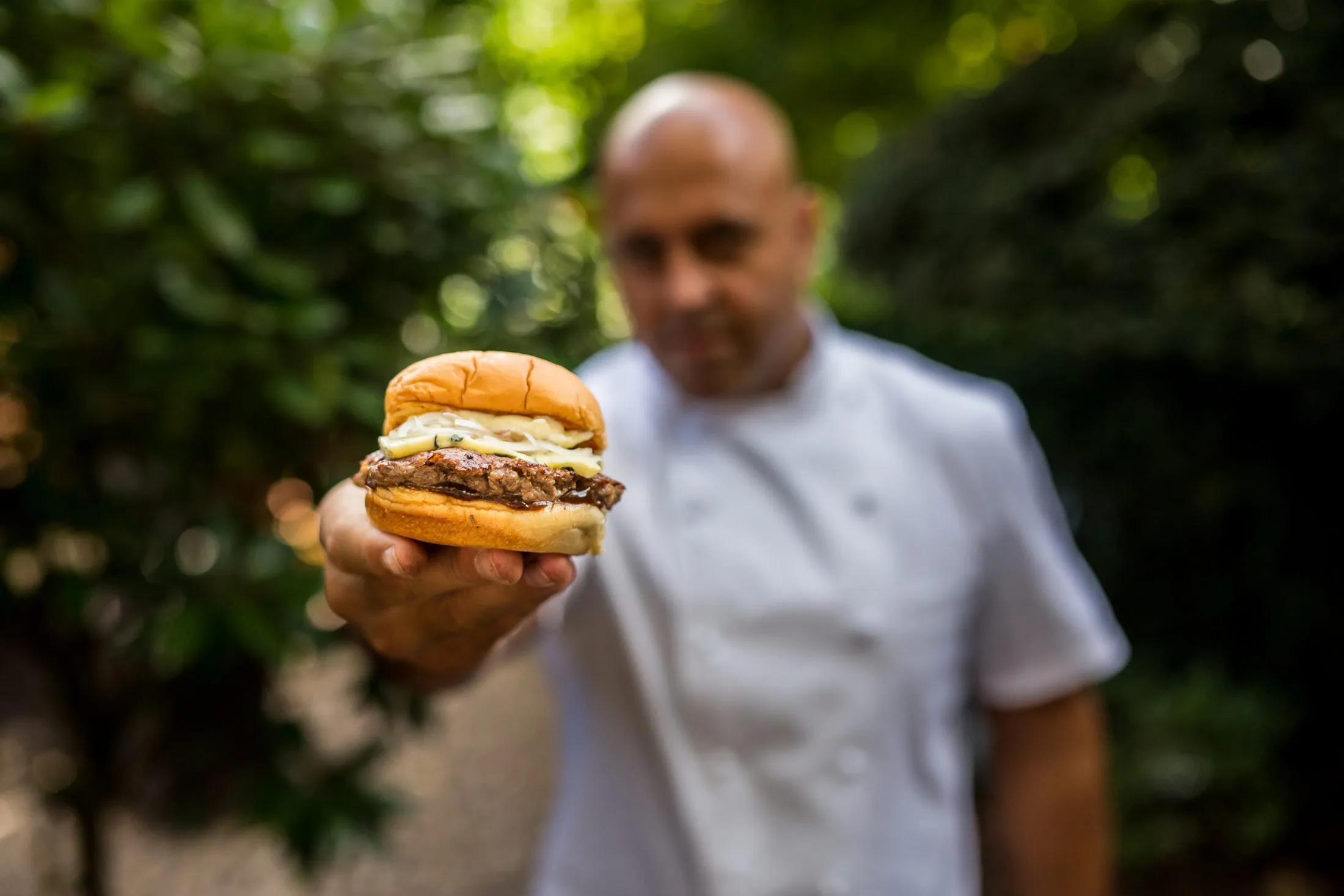 Chef Sat Bains poses for a photo with the Major Oak Burger.
