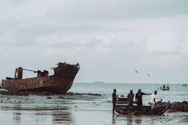 Fisherman near a decaying boat on a beach in Beira. 