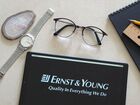 In this photo illustration, an Ernst & Young logo seen