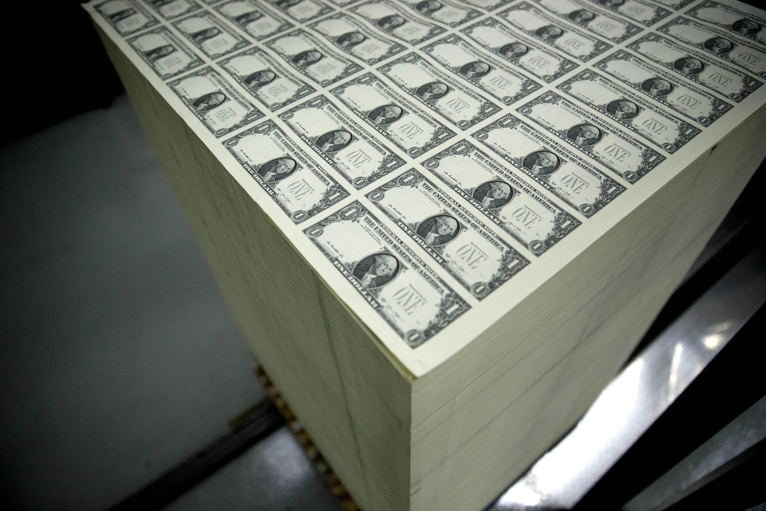 Dollar note sheets in a stack.