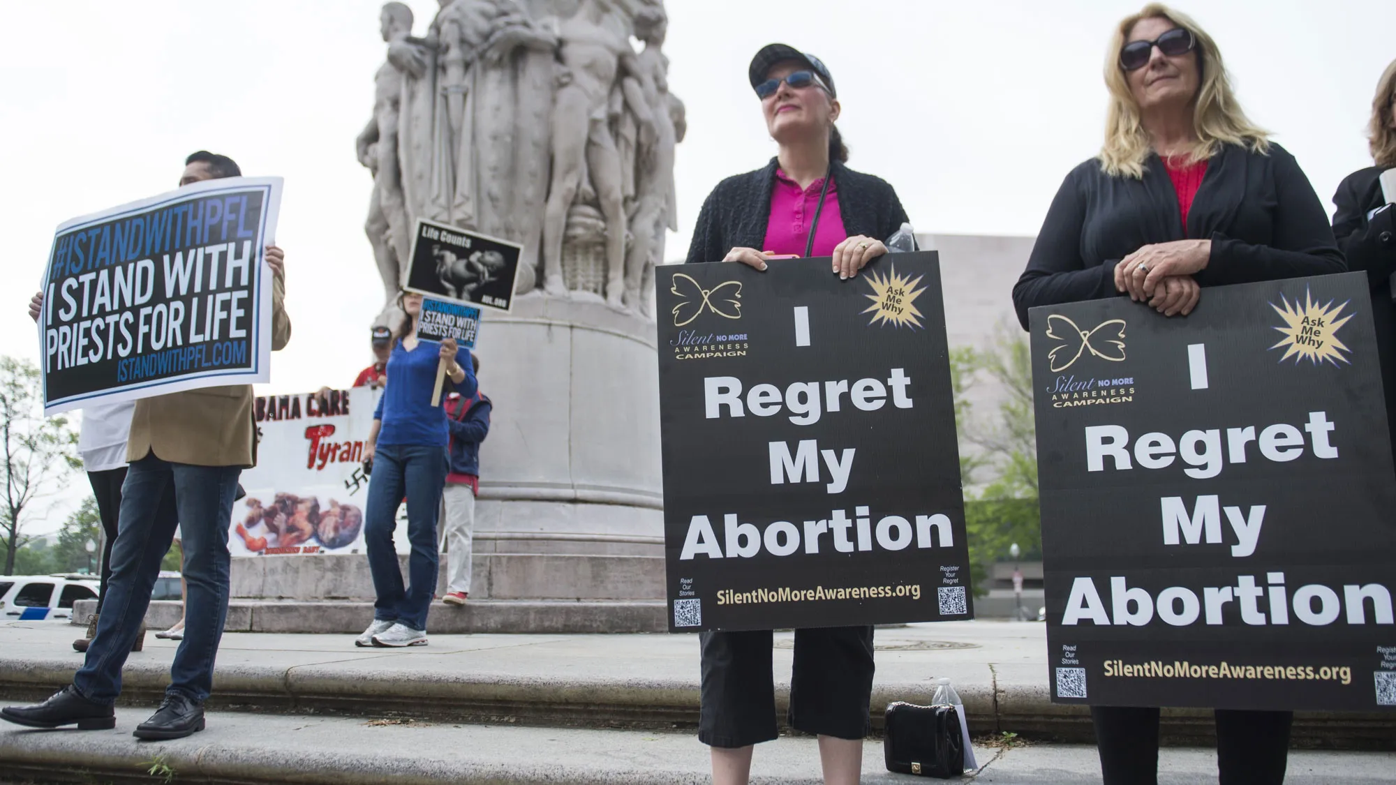 Anti-abortion demonstrators hold signs stating they regret their abortions during a Priests for Life protest outside the US Court of Appeals for the DC Circuit Court as the Court hears the oral arguments in the 'Priests for Life v. US Department of Health and Human Services (HHS)' case in Washington, DC, on May 8, 2014.
