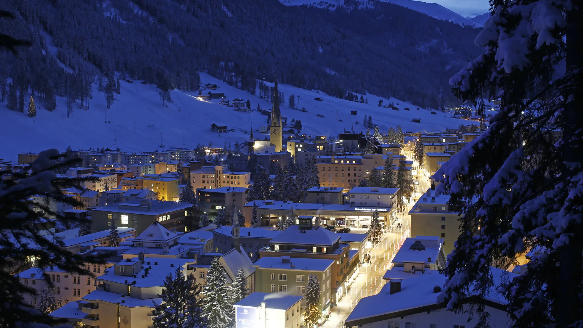 Residential buildings stand illuminated on the town skyline ahead of the World Economic Forum in Davos, Switzerland.
