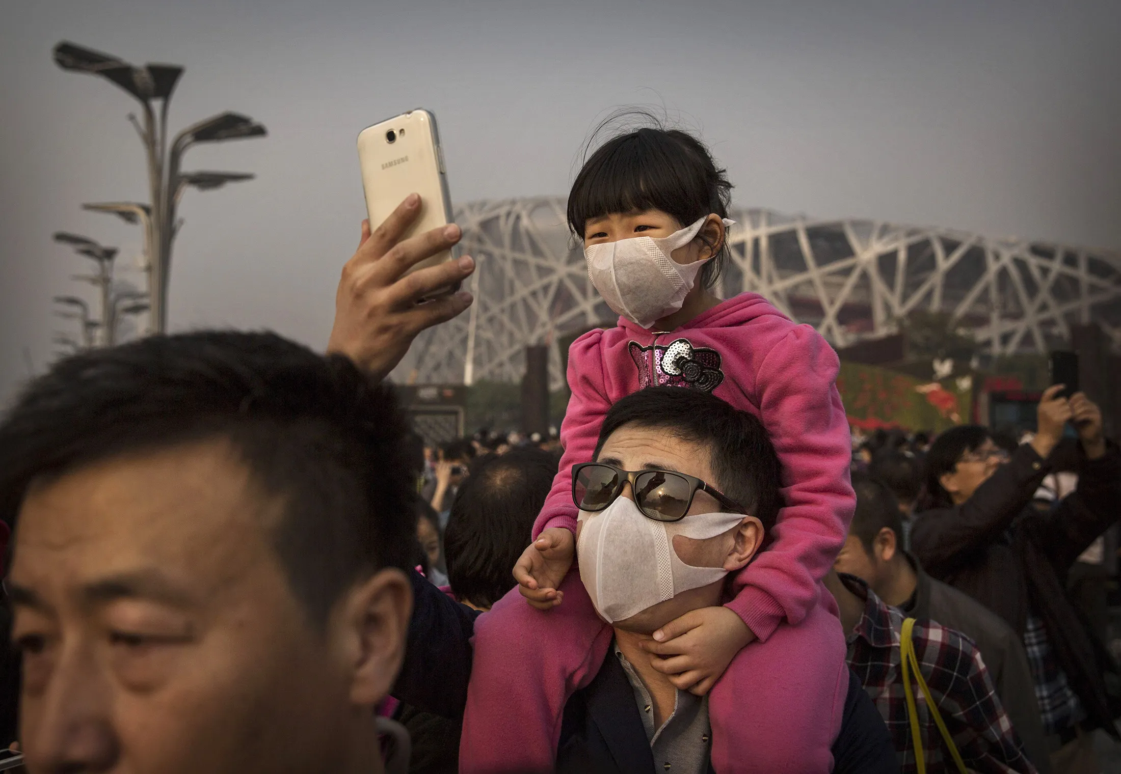 A Chinese man and his daughter wear masks to protect against pollution in Beijing, China.
