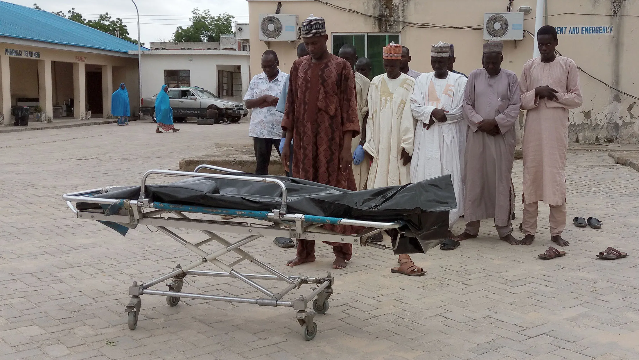 People pray over the body of a victim in the grounds of the State Specialist Hospital in Maiduguri, northeastern Nigeria on July 29, 2017 the day after two suicide bombers struck a camp for displaced people in Dikwa, 90 kilometres (56 miles) east of Maiduguri, killing five. Civilian militia member Babakura Kolo said the attackers disguised themselves as traders wanting to buy grain. / AFP PHOTO / STRINGER (Photo credit should read STRINGER/AFP/Getty Images)
