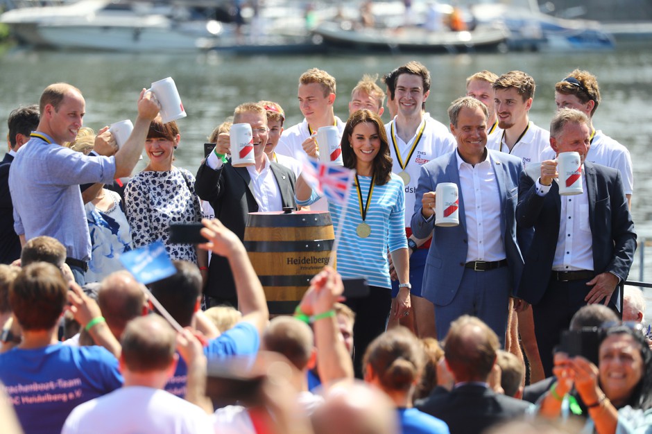 Britain's Prince William and his wife Catherine, the Duchess of Cambridge, raise beer mugs after a boat race between the twinned towns of Cambridge and Heidelberg, Germany, in Heidelberg in July 2017.